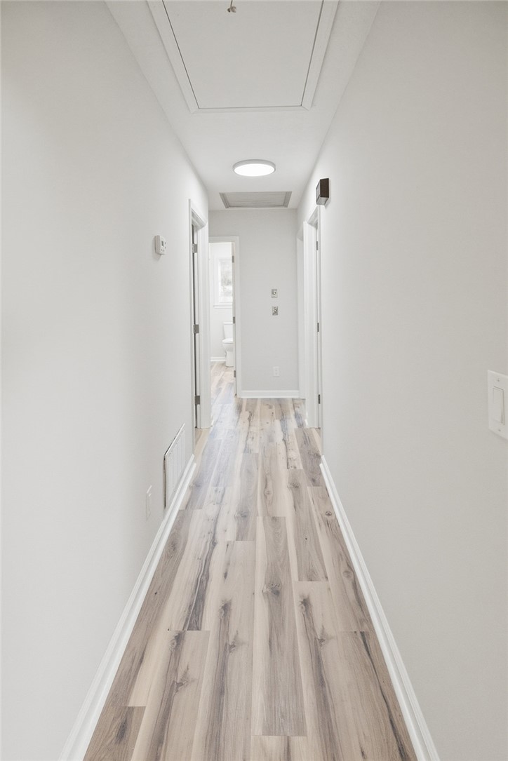 902 Cherokee Road Pelzer, SC 29669 - Photo 9 of 38 Streamlined hallway with durable plank flooring, offering access to various rooms.