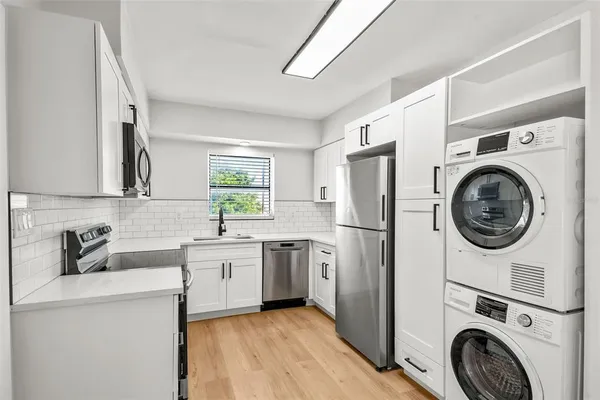 a kitchen with a sink a refrigerator and cabinets