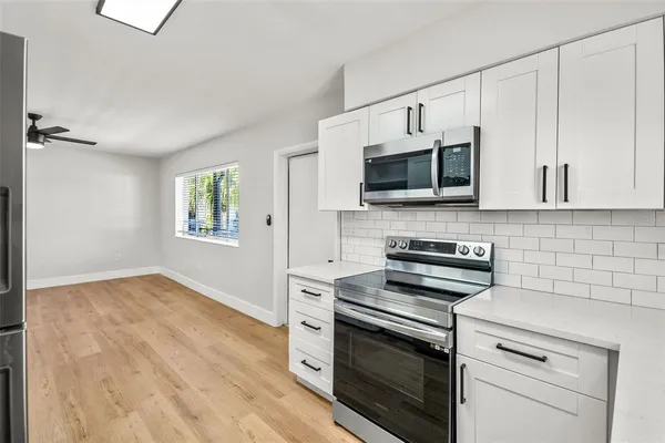 a kitchen with white cabinets stainless steel appliances and sink