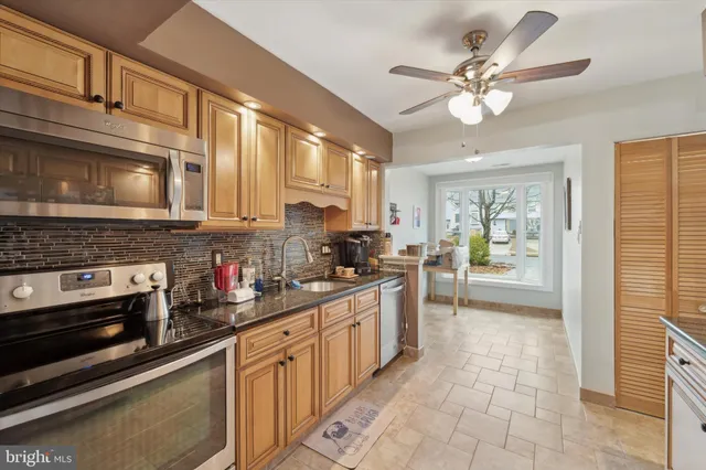 a kitchen with stainless steel appliances granite countertop a stove cabinets and microwave