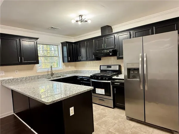 a kitchen with stainless steel appliances granite countertop a sink stove and refrigerator