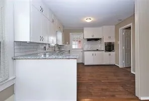 a kitchen with stainless steel appliances granite countertop a sink stove and cabinets