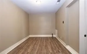 a view of a room with wooden floor and a window