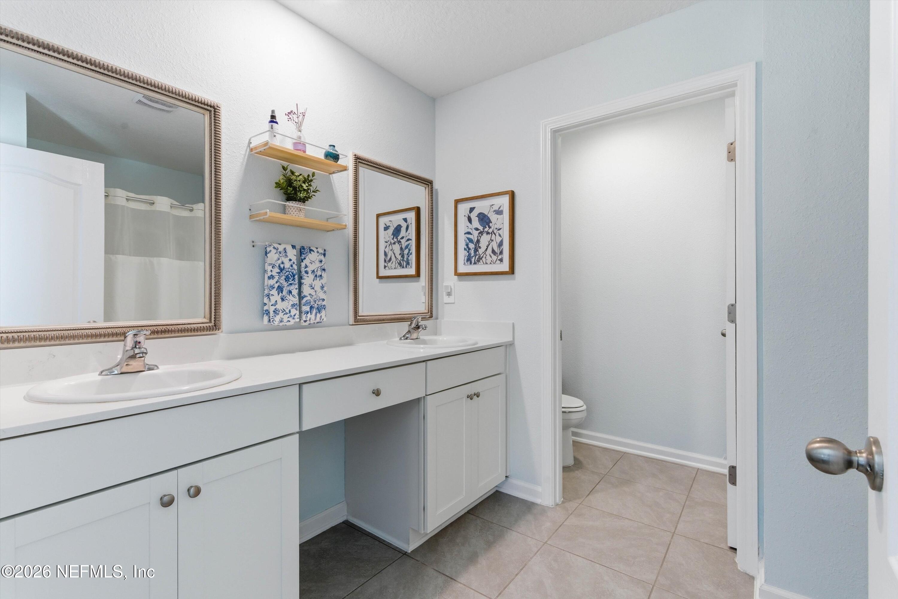 103 Seaport Breeze Road St. Augustine, FL 32095 - Photo 20 of 44 a bathroom with a granite countertop sink mirror and toilet