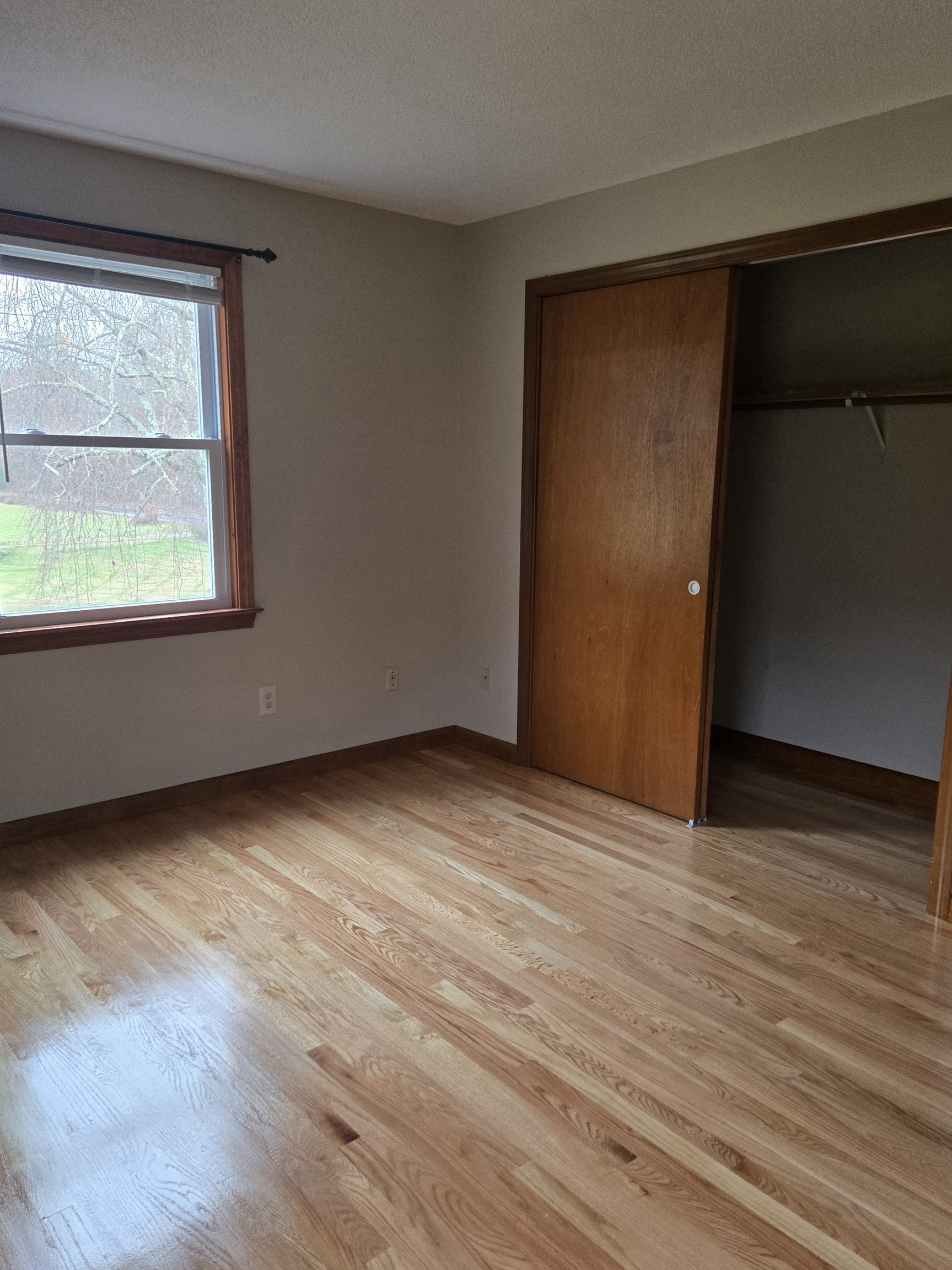 48 River Road Mansfield, CT 06250 - Photo 18 of 27 an empty room with wooden floor and windows
