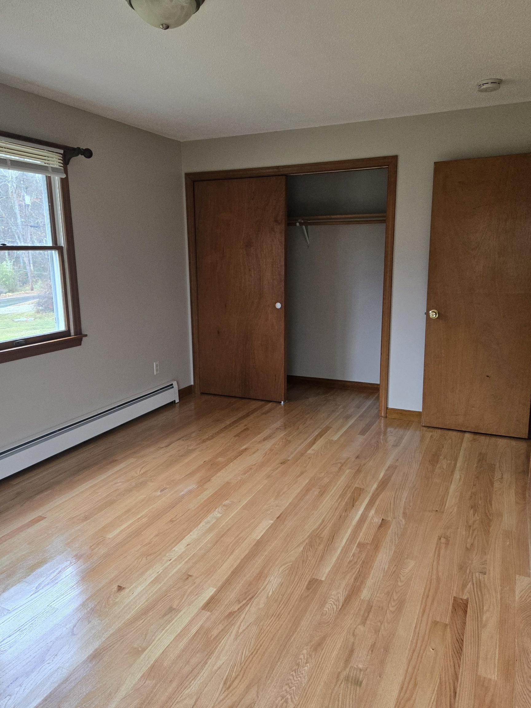 48 River Road Mansfield, CT 06250 - Photo 20 of 27 an empty room with wooden floor and windows