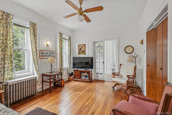 a view of a livingroom with furniture a flat screen tv and wooden floor