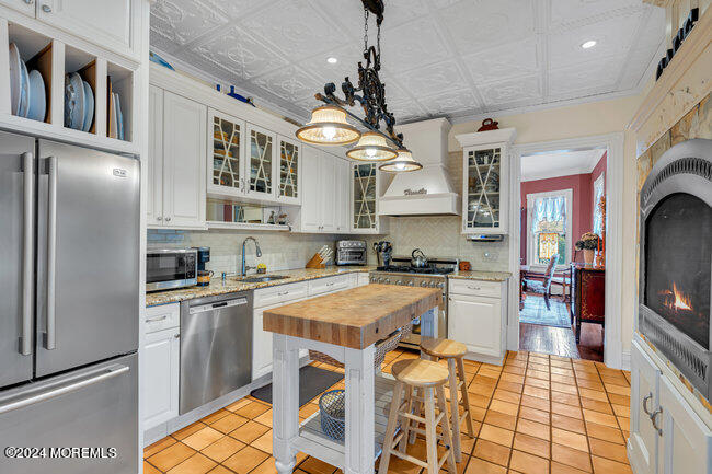 116 Washington Avenue Spring Lake, NJ 07762 - Photo 13 of 26 a kitchen with stainless steel appliances granite countertop a refrigerator a sink dishwasher a stove and white cabinets with wooden floor