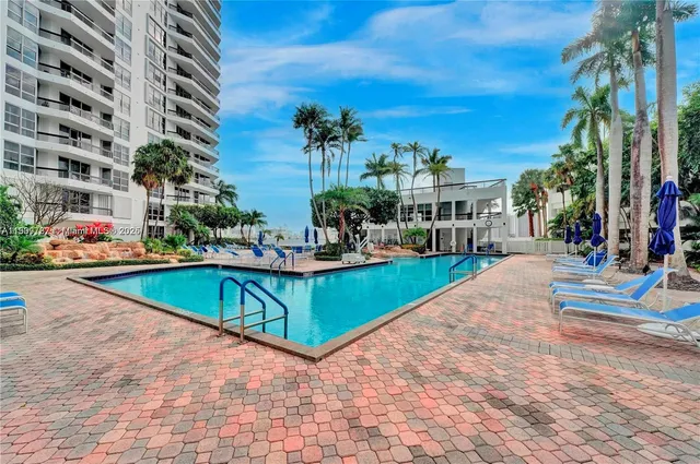 a view of a swimming pool with a bench in front of it