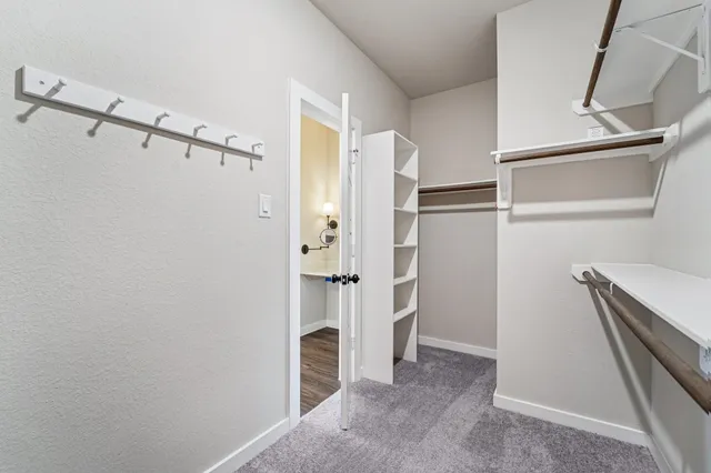 a view of walk in closet with empty racks