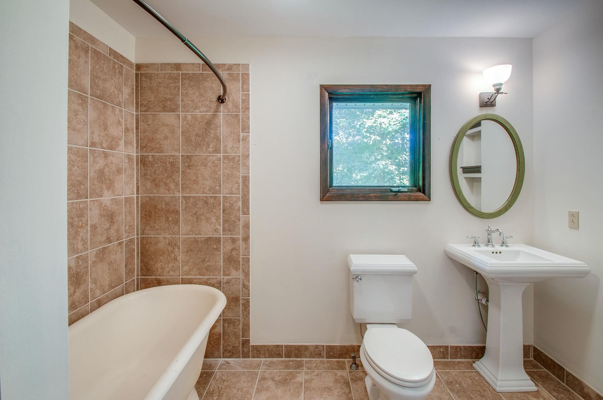 7426 Pinewood Road Franklin, TN 37064 - Photo 16 of 30 a bathroom with a toilet a sink a mirror and a shower