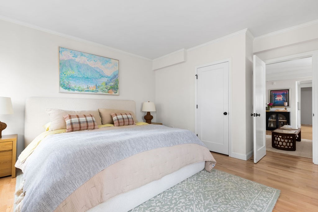 20 Chapel Street, Unit B712 Brookline, MA 02446 - Photo 13 of 25 a bedroom with a bed and wooden floor