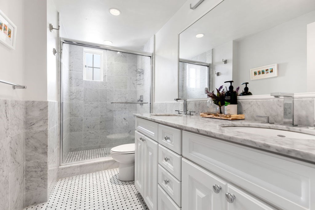 20 Chapel Street, Unit B712 Brookline, MA 02446 - Photo 15 of 25 a bathroom with a double vanity sink toilet and shower