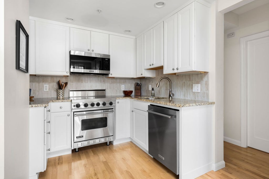 20 Chapel Street, Unit B712 Brookline, MA 02446 - Photo 7 of 25 a kitchen with stainless steel appliances granite countertop a stove a sink and a refrigerator