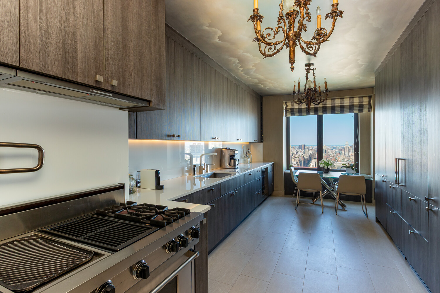 117 East 57th Street, Unit 49D/51D Manhattan, NY 10022 - Photo 8 of 46 a kitchen with a stove and a chandelier