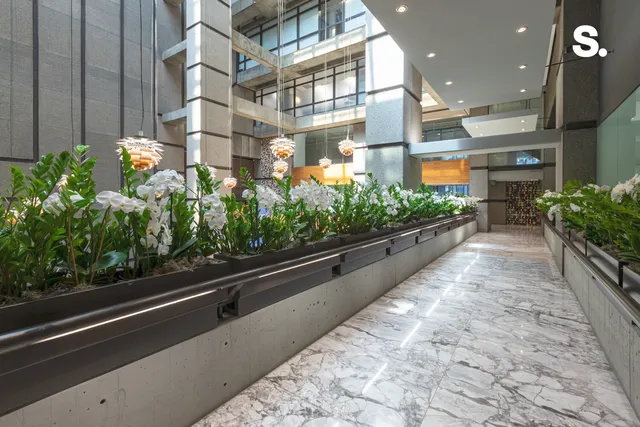 a lobby with furniture and potted plants
