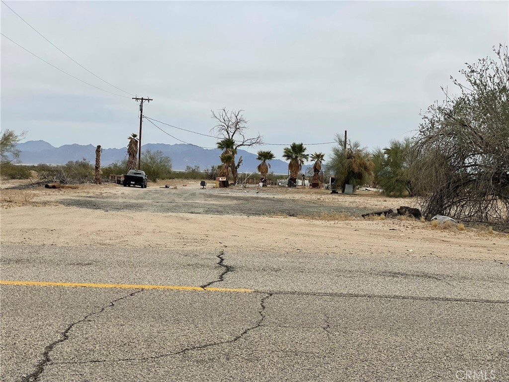 25550 Kaiser Road Desert Center, CA 92239 - Photo 12 of 13 a view of a road with a yard and trees in the background