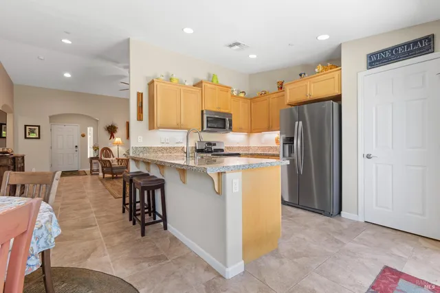 a kitchen with refrigerator and chairs