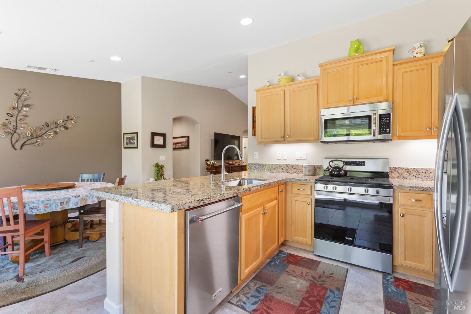 412 Spring Creek Drive Rio Vista, CA 94571 - Photo 15 of 42 a kitchen with stainless steel appliances granite countertop a stove top oven a sink dishwasher and cabinets with wooden floor