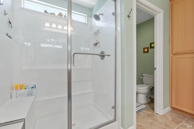 a bathroom with a granite countertop shower a toilet and a sink
