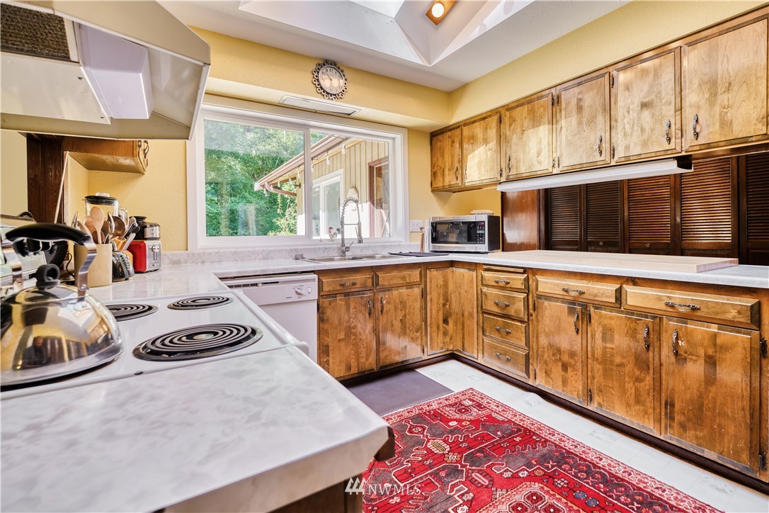 2172 Foxhole Road Point Roberts, WA 98281 - Photo 19 of 40 a kitchen with stainless steel appliances granite countertop a stove a sink and a microwave