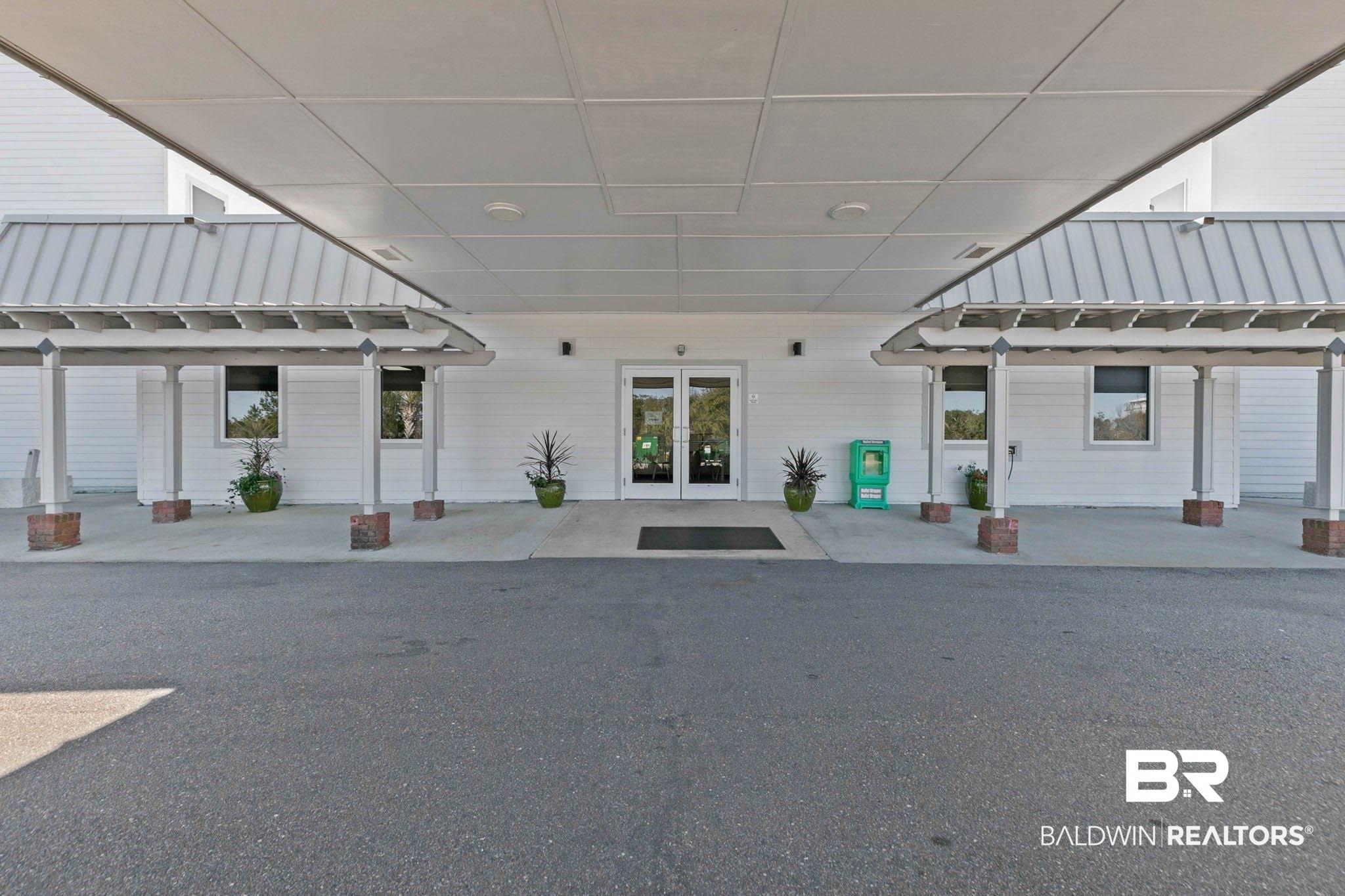 400 Plantation Road, Unit 4501 Gulf Shores, AL 36542 - Photo 20 of 30 Covered entrance with double glass doors, white siding, and a prominent metal roof