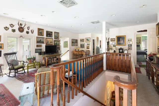 a living room with furniture a flat screen tv and floor to ceiling window