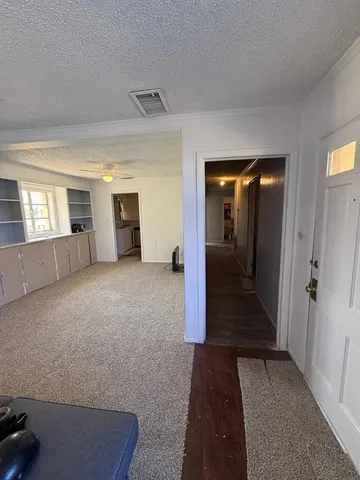 a view of a hallway with wooden floor and windows