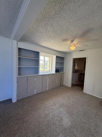 an empty room with a fireplace and cabinet