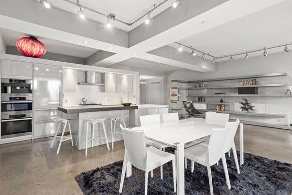 a kitchen with stainless steel appliances kitchen island granite countertop a table chairs and white cabinets