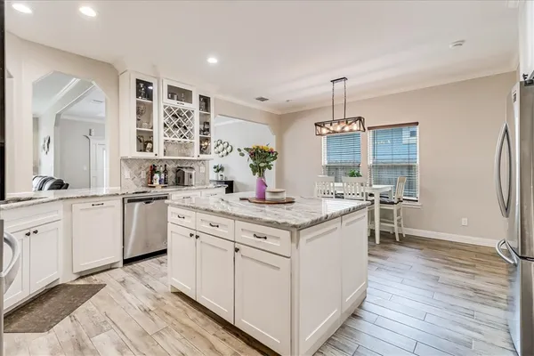 a kitchen with granite countertop a sink stainless steel appliances and cabinets