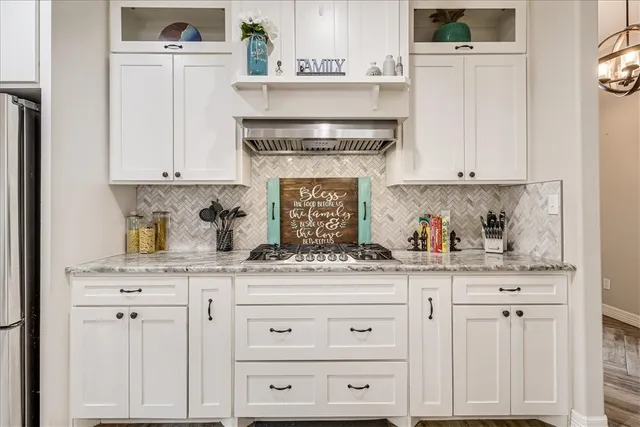 a kitchen with granite countertop white cabinets and white appliances