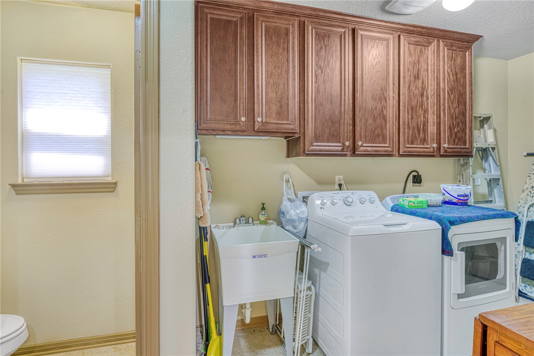 9945 Oxford Cemetery Road Madisonville, TX 77864 - Photo 17 of 42 Laundry area featuring cabinet space, separate washer and dryer, and a textured ceiling