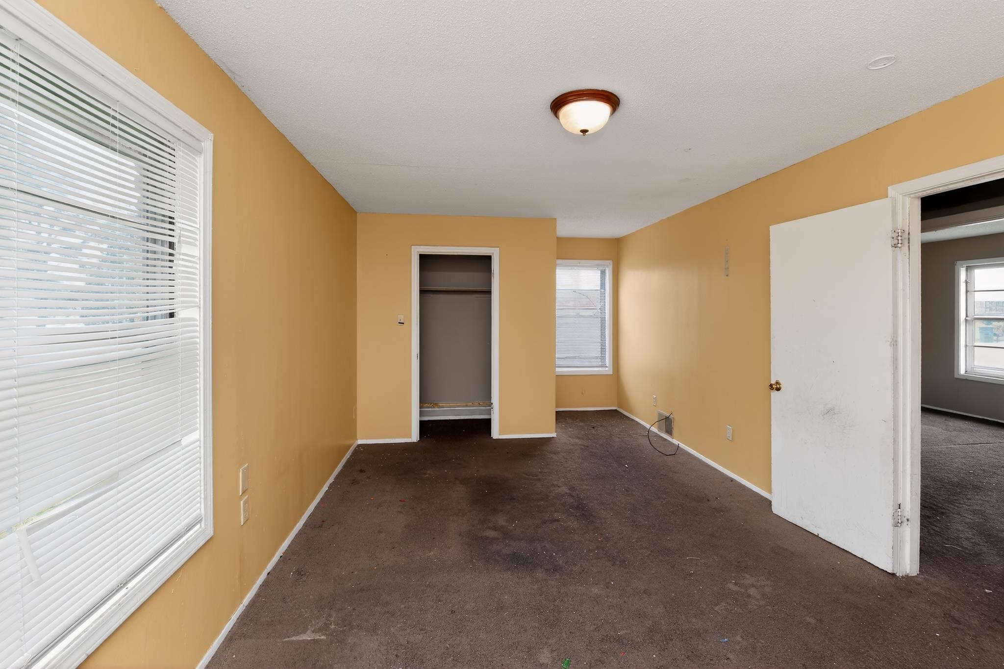 645 Parkrose Road Memphis, TN 38109 - Photo 16 of 32 Spacious room featuring multiple windows, a ceiling-mounted light fixture, and an open closet