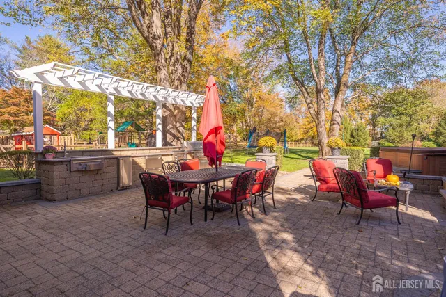 a backyard of a house with dining table and chairs with plants
