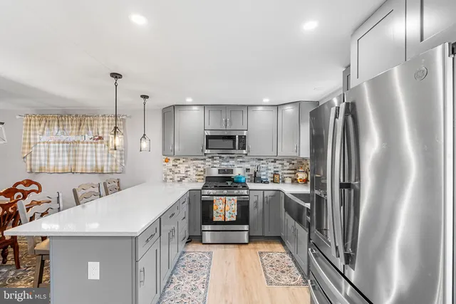 a kitchen with stainless steel appliances a refrigerator a stove a sink and a center island