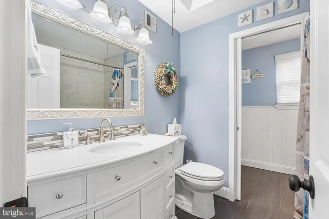 a bathroom with a toilet a sink and a mirror