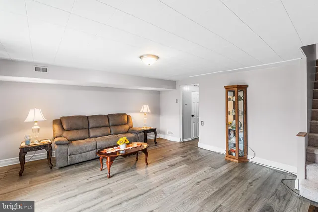 a living room with furniture and a flat screen tv with wooden floor