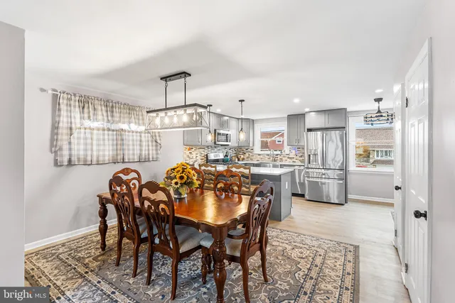 a view of a dining room and kitchen with furniture and a chandelier