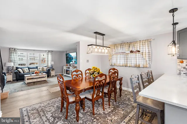 a dining room with furniture a chandelier and wooden floor