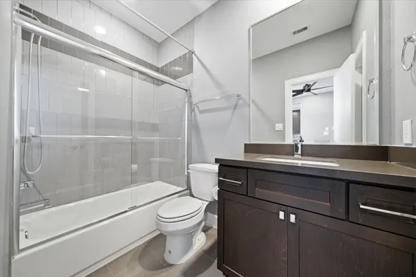 a bathroom with a bathtub shower sink vanity and toilet