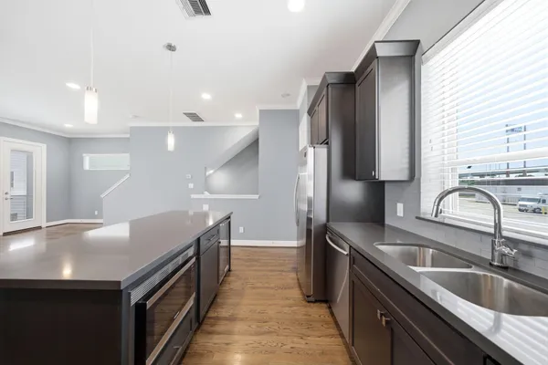 a kitchen with granite countertop a sink and refrigerator