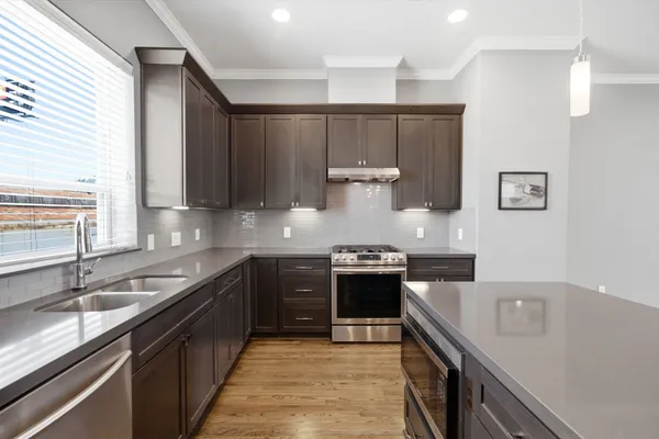 a kitchen with stainless steel appliances granite countertop a sink stove and refrigerator