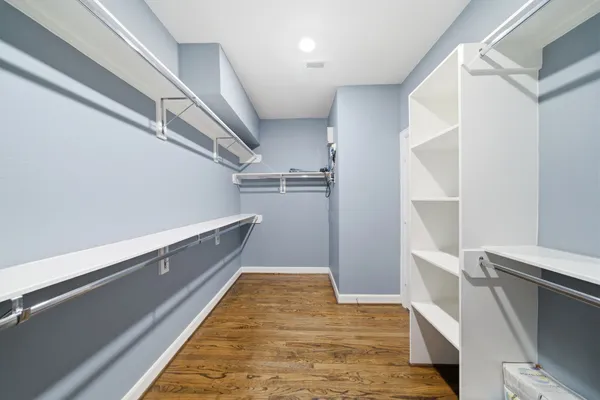 a hallway with white cabinets and wooden floor
