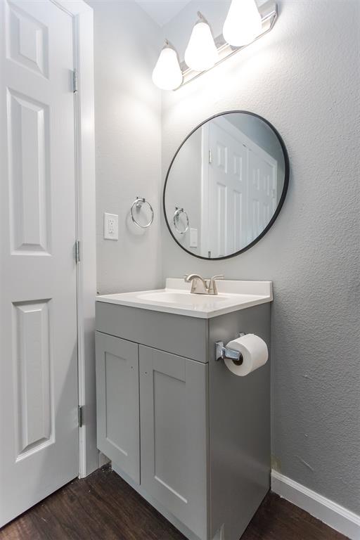 300 South 3rd Street Bonham, TX 75418 - Photo 4 of 14 a bathroom with a sink mirror and vanity
