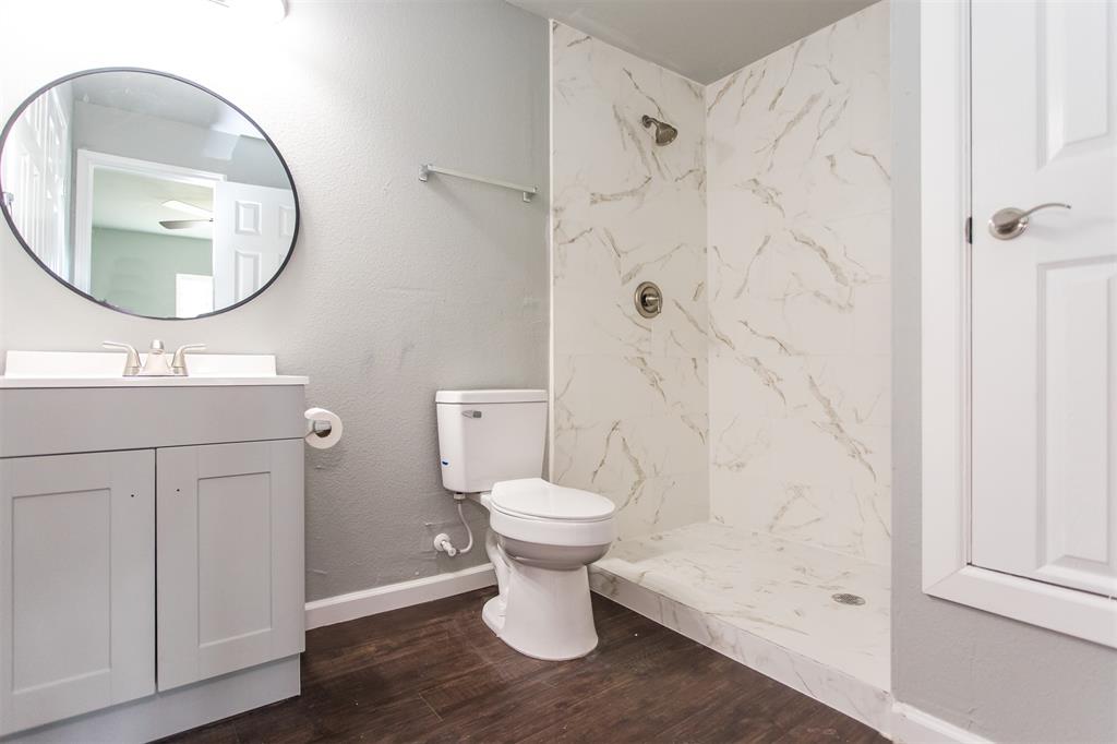 300 South 3rd Street Bonham, TX 75418 - Photo 5 of 14 a bathroom with a toilet sink and a mirror