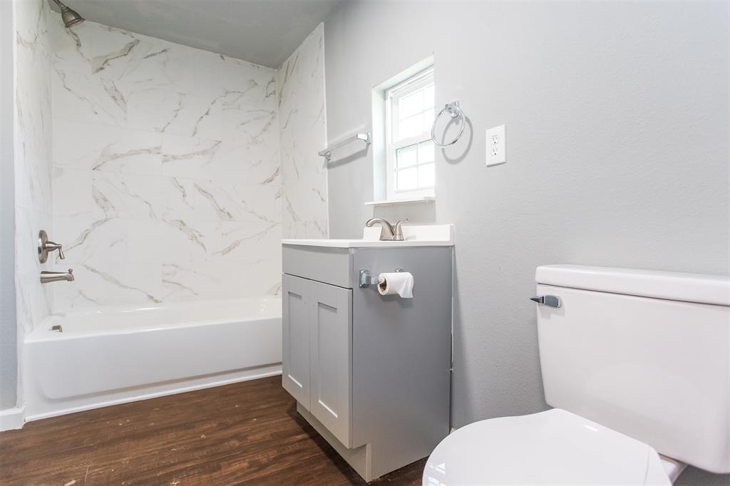 300 South 3rd Street Bonham, TX 75418 - Photo 7 of 14 a bathroom with a sink a toilet and bathtub
