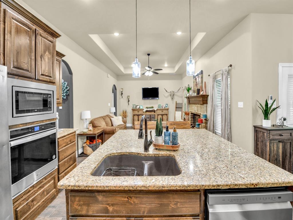 156 Cottongame Road Weatherford, TX 76088 - Photo 9 of 35 a kitchen with kitchen island a sink stove and microwave