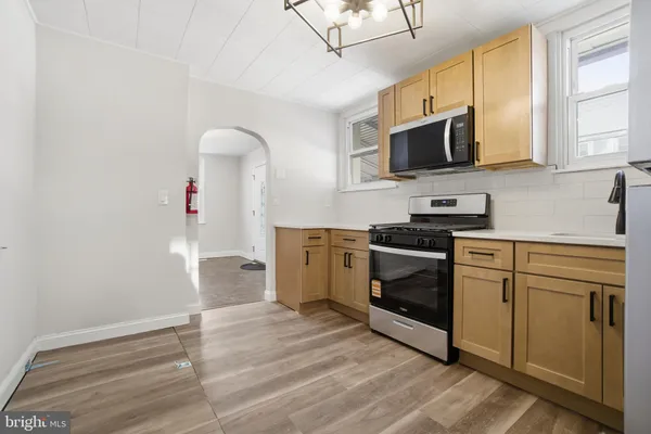 a kitchen with stainless steel appliances a stove microwave and sink