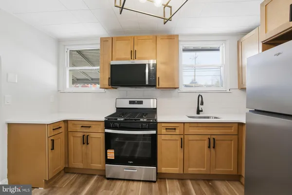 a kitchen with stainless steel appliances a stove sink microwave and refrigerator